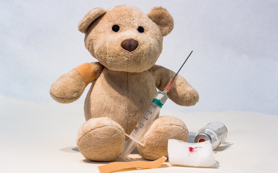 Beispielbild Kinderimpfung, Teddybär mit Pflaster und Spritze