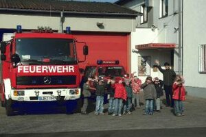 Kinder vor einem Feuerwehrfahrzeug