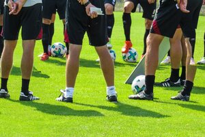Beispielfoto: Förderprogramm Sport integriert Hessen, Beine von Fußballspielern mit Ball auf Rasen