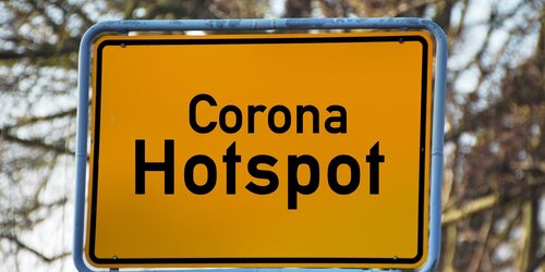 Beispielbild Gelbes Schild mit Aufschrift Corona-Hotspot