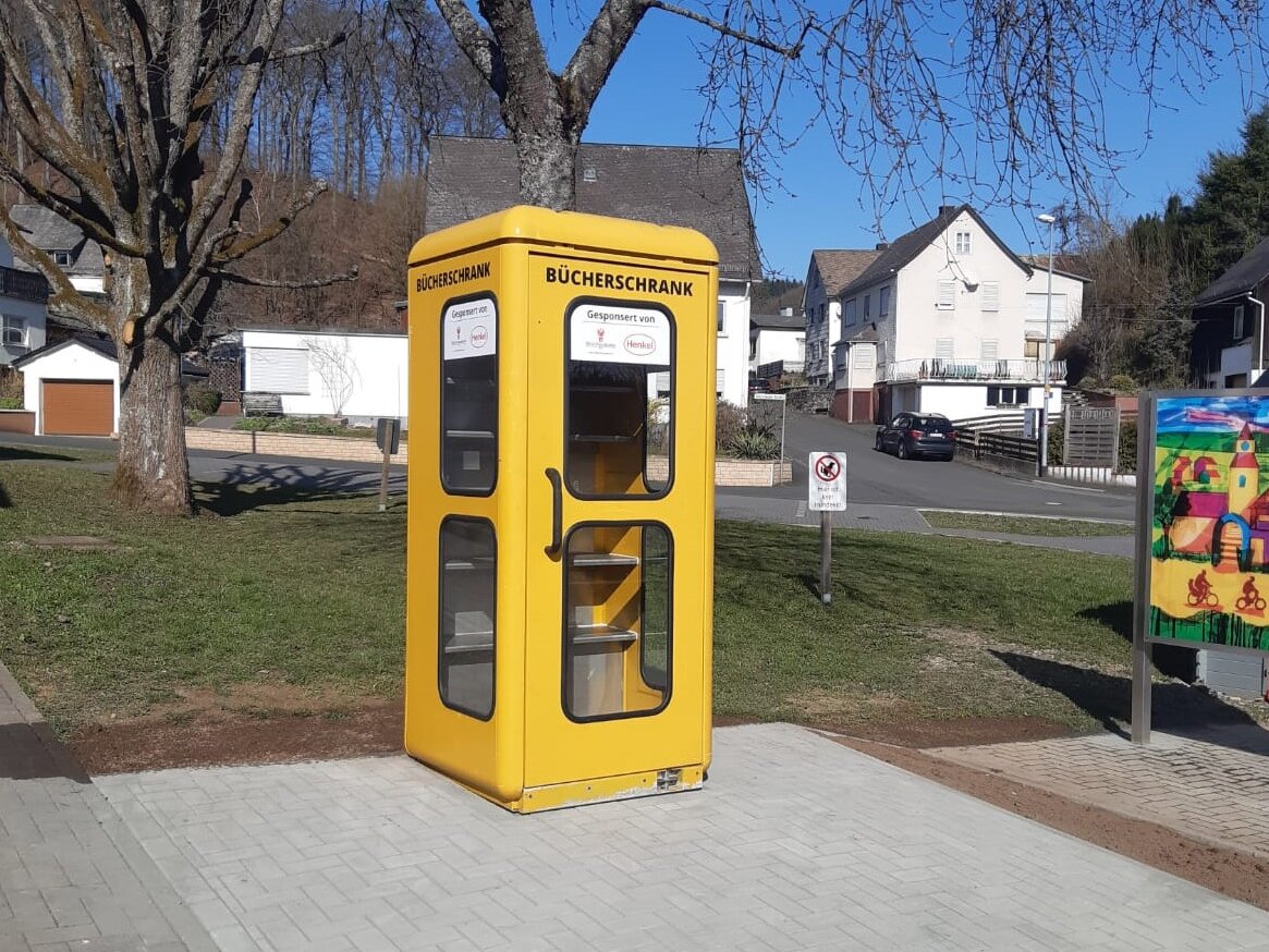 Eine alte gelbe Telefonzelle wurde zum Bücherschrank umgebaut.