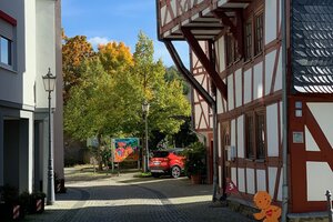Straßenansicht eines Fachwerkhauses mit über Fahrbahn ragendem Obergeschoss