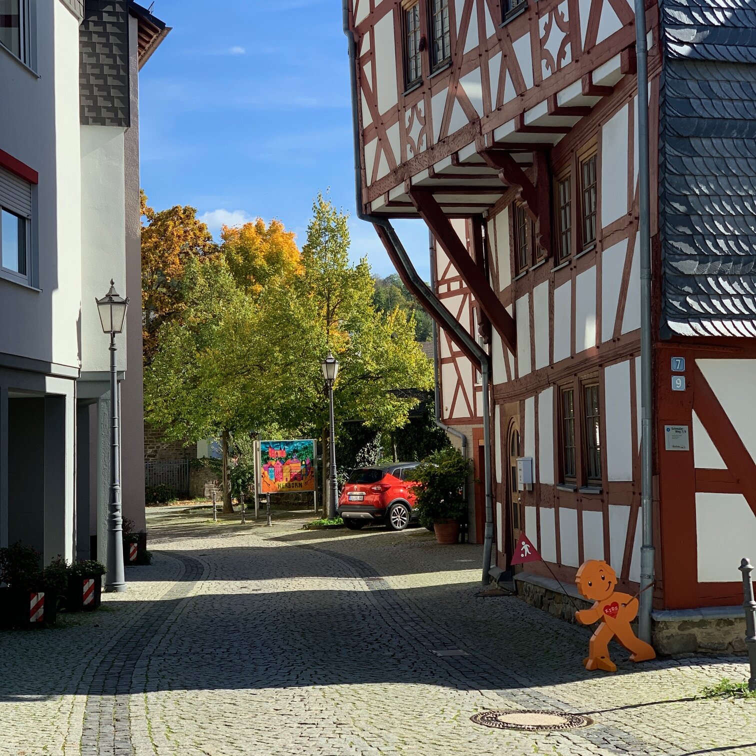 Straßenansicht eines Fachwerkhauses mit über Fahrbahn ragendem Obergeschoss