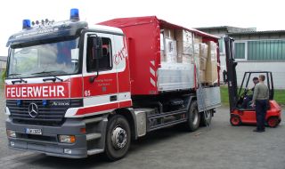 Mitarbeiter der Feuerwehr beim Beladen eines LKWs