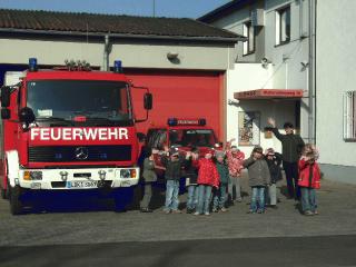 Kinder vor einem Feuerwehrfahrzeug
