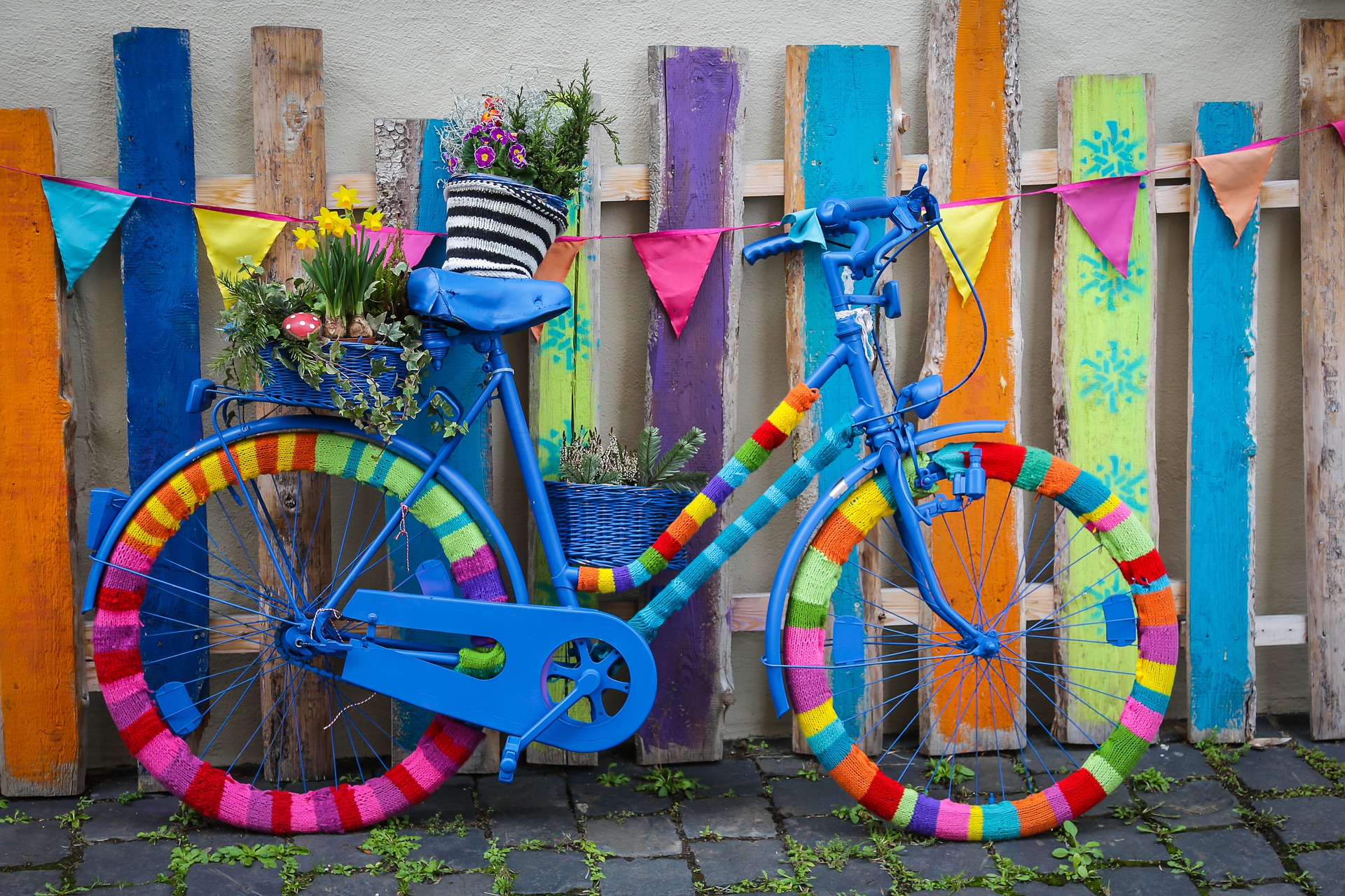 Buntes Fahrrad vor buntem Zaun.