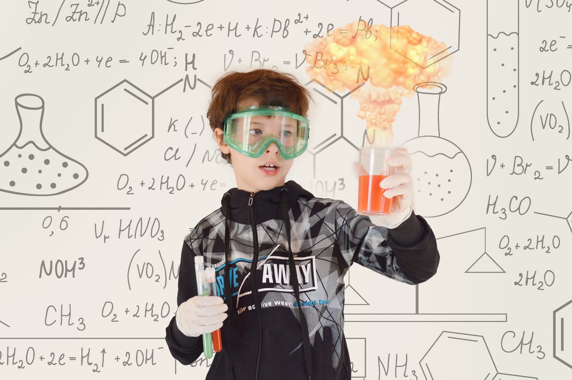 Kind mit Laborbrille und Laborkolben.