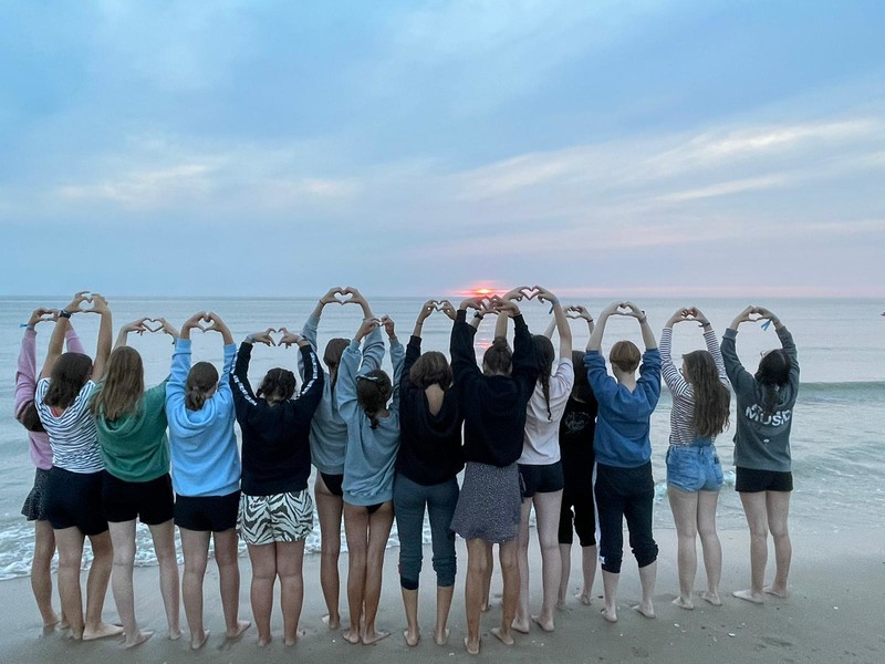 Jugendliche bei einer Freizeit am Meer, Hände zum Herz geformt