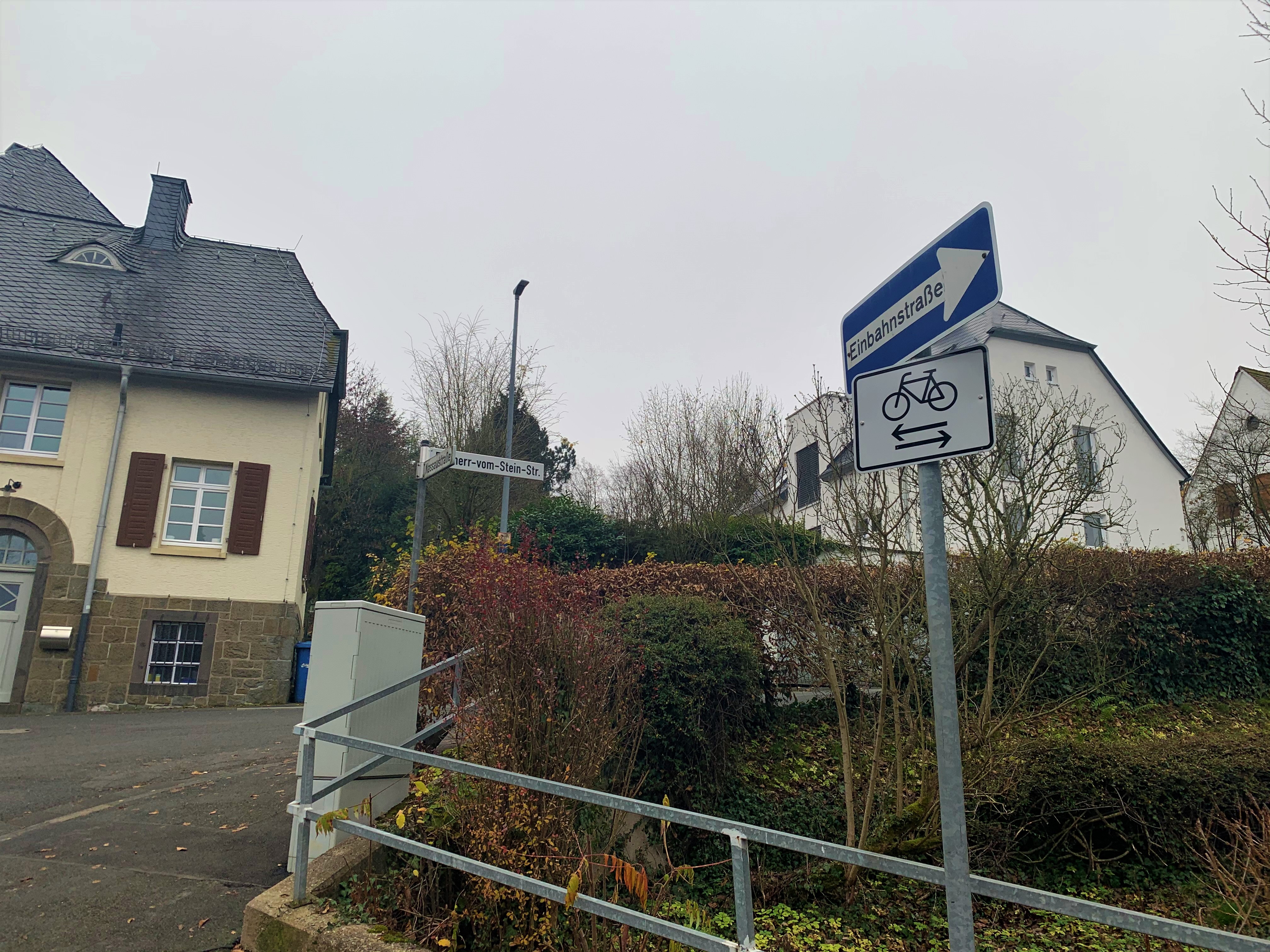 Beispielbild: Blaues Schild einer Einbahnstraße und Fahrradsymbol zeigen an, dass die Einbahnstraße entgegen der Fahrtrichtung von Radfahrer genutzt werden darf.